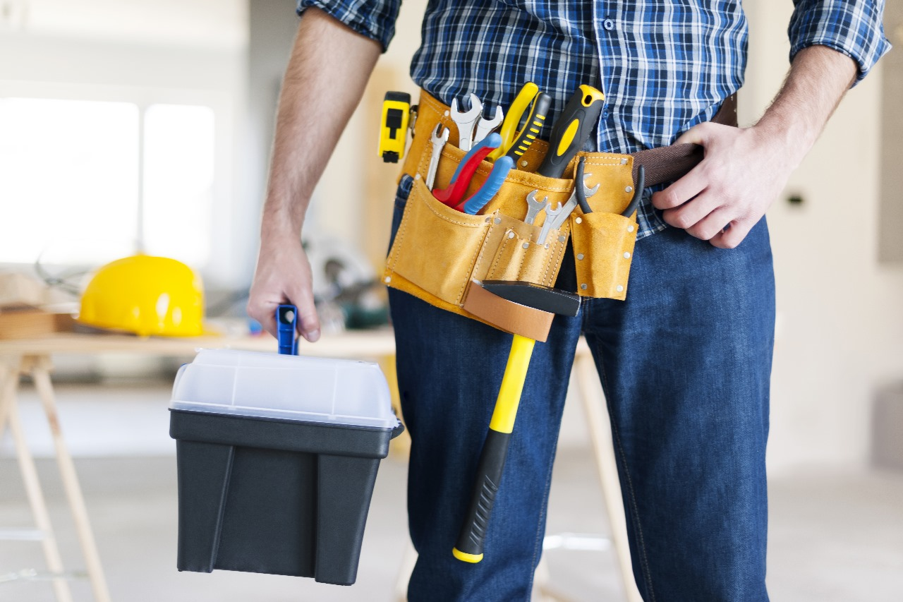 Handwerker mit Werkzeuggürtel und Werkzeugkoffer